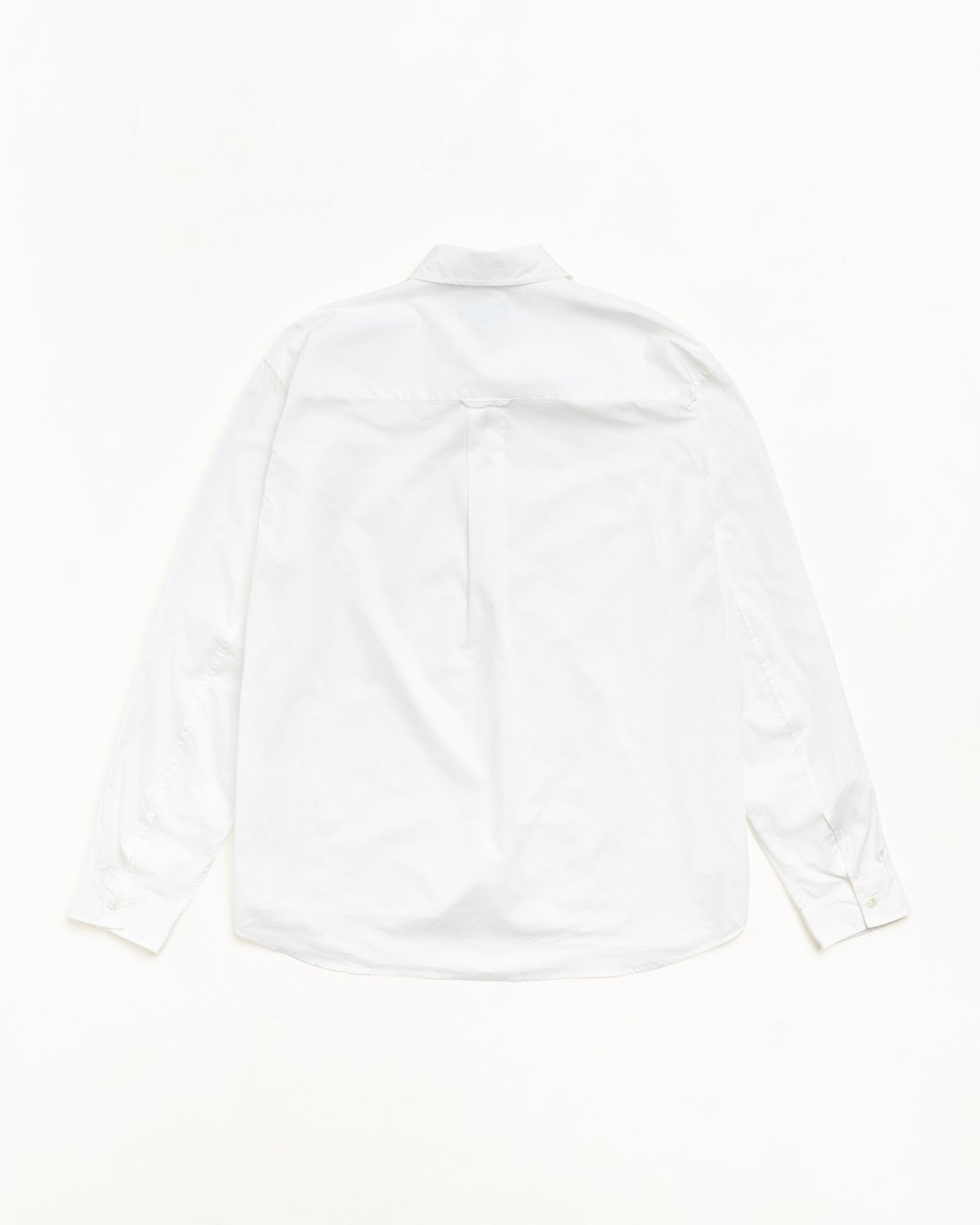 Back View Of Unisex White Long Sleeve Shirt With Yoke Pleat, Buttoned Cuffs, Curved Hem