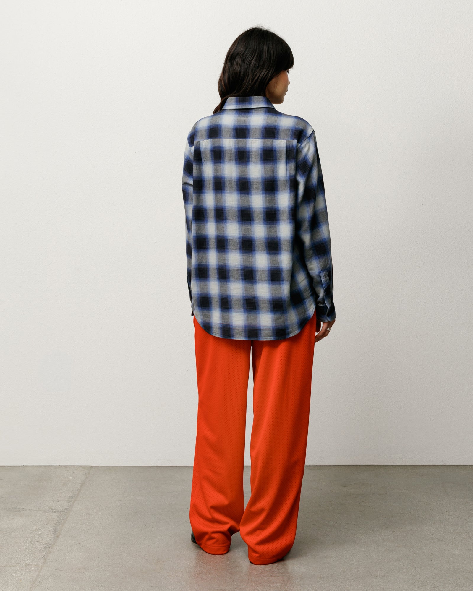 Back view of unisex long-sleeve ombre plaid shirt in black on model