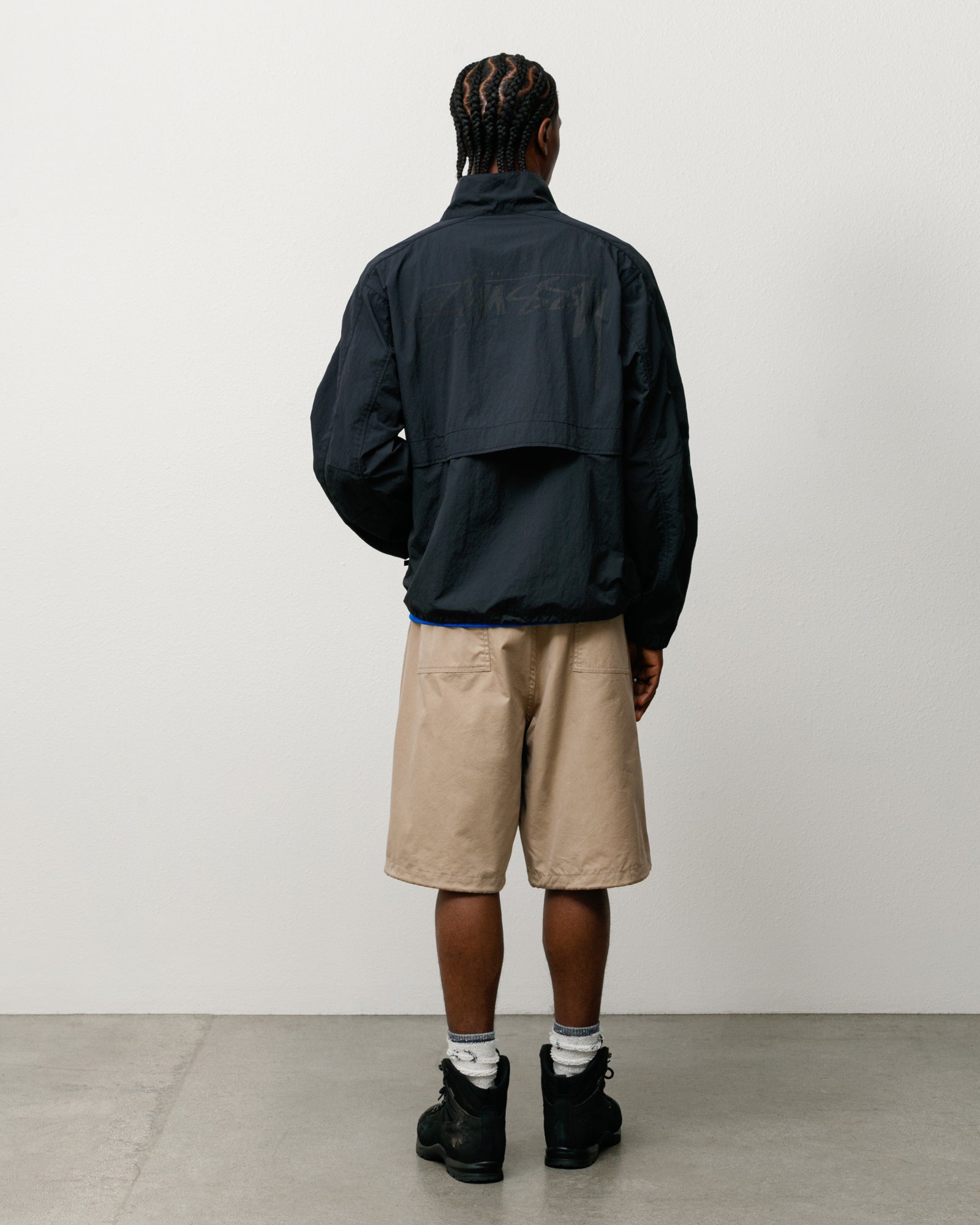 Khaki shorts on model, back view with patch pockets and relaxed knee-length fit