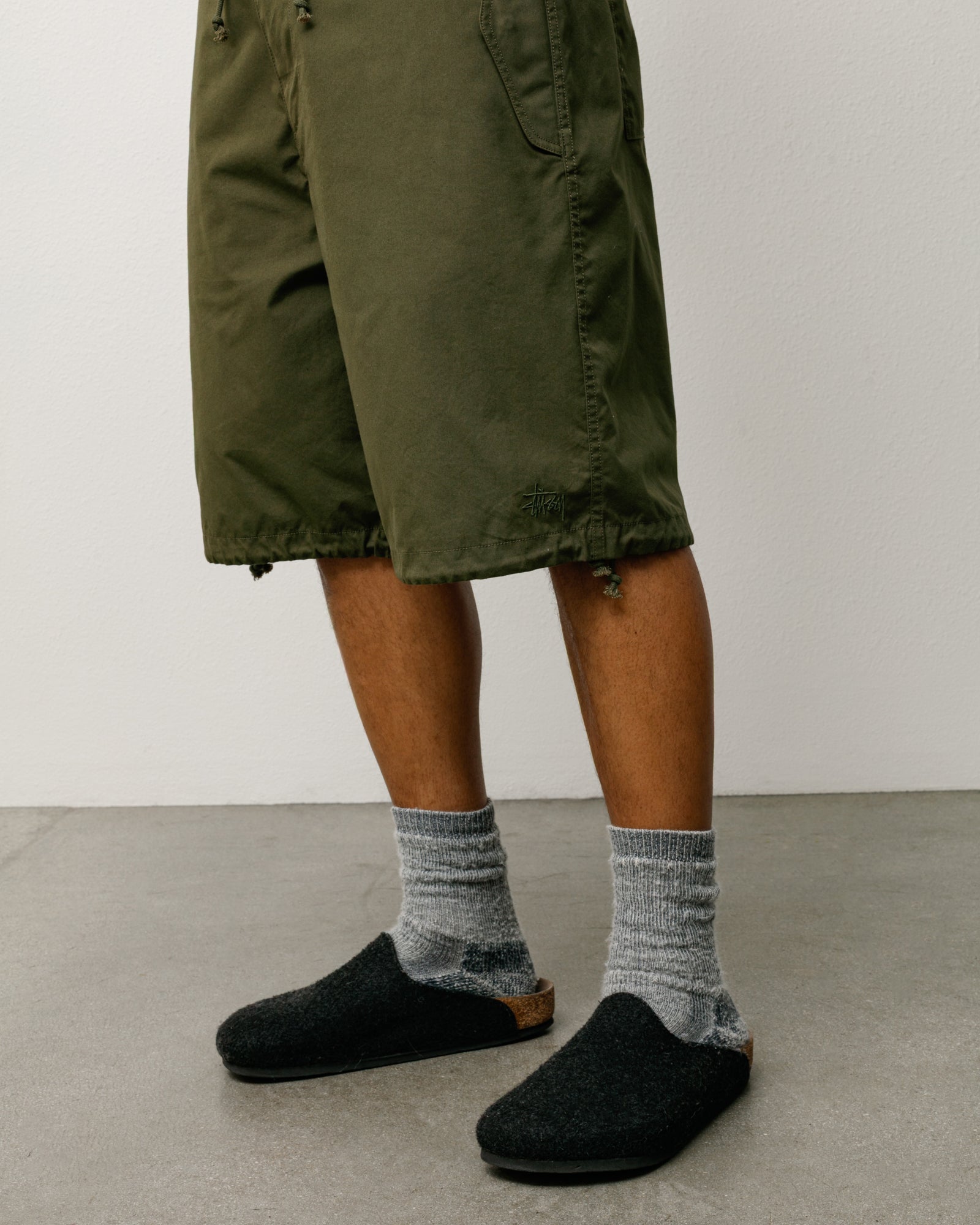 Olive green baggy shorts with drawcord hem, flap pockets and logo embroidery on the leg.