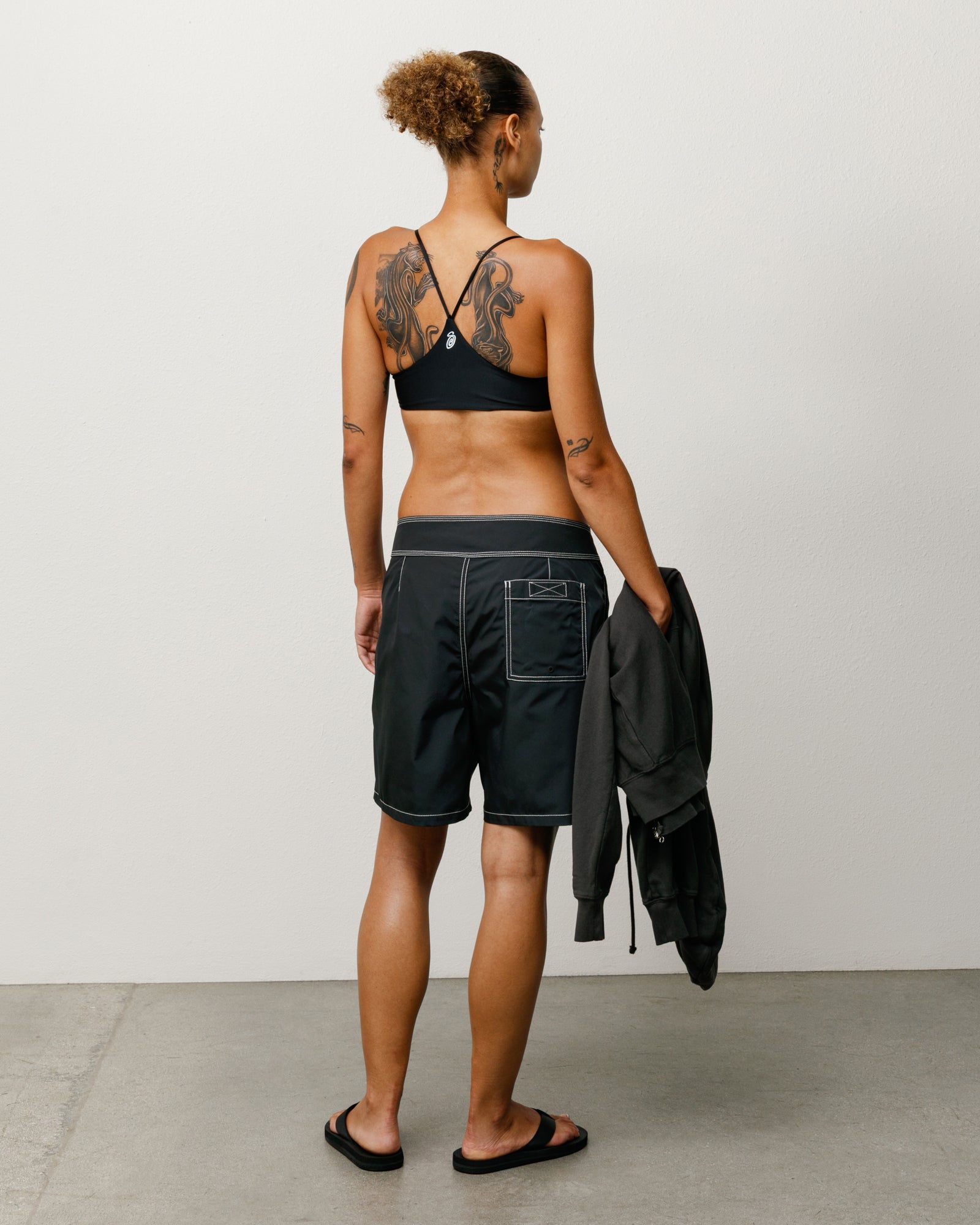 Coastal Board Short unisex in black, back view showing white contrast stitching and rear patch pocket