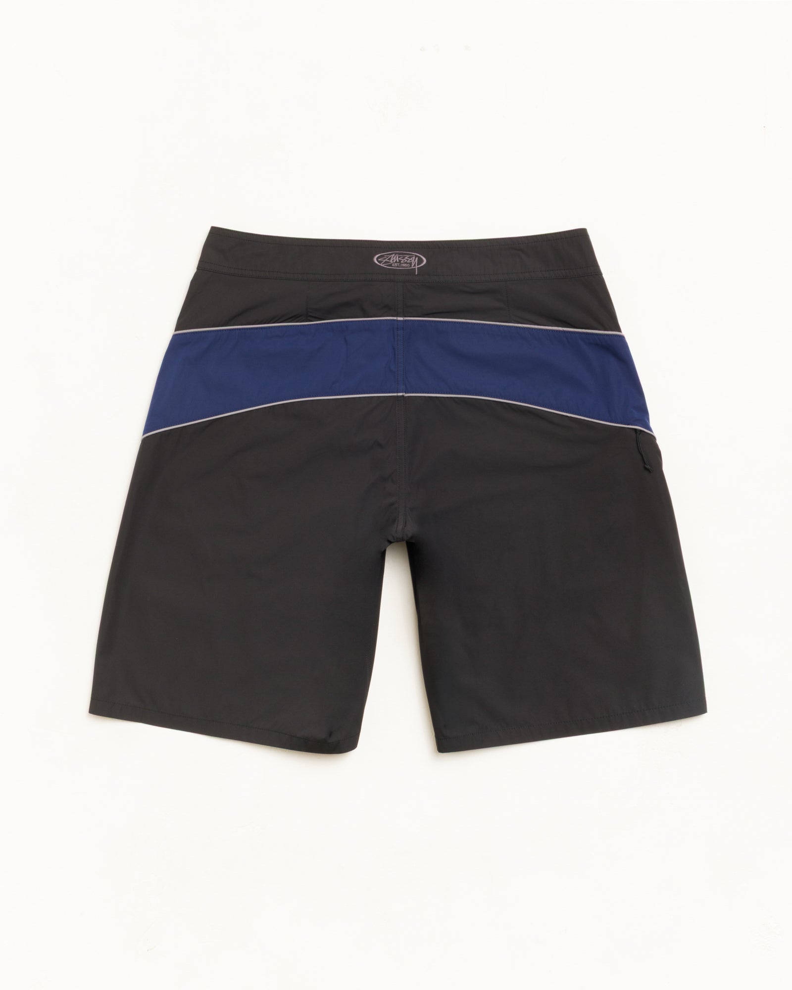 Cove Board Short bas noir avec bande marine contrastée et passepoil, coupe décontractée unisexe.