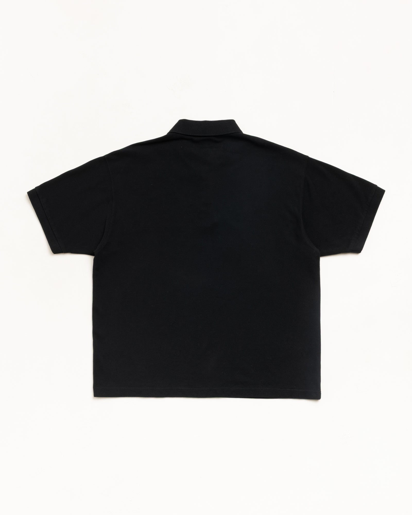 Black pique polo shirt, unisex short sleeve, back view on clean white background