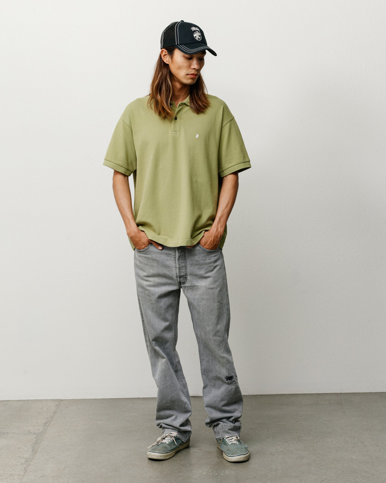 Leaf green unisex pique polo shirt with short sleeves, on-model studio shot.