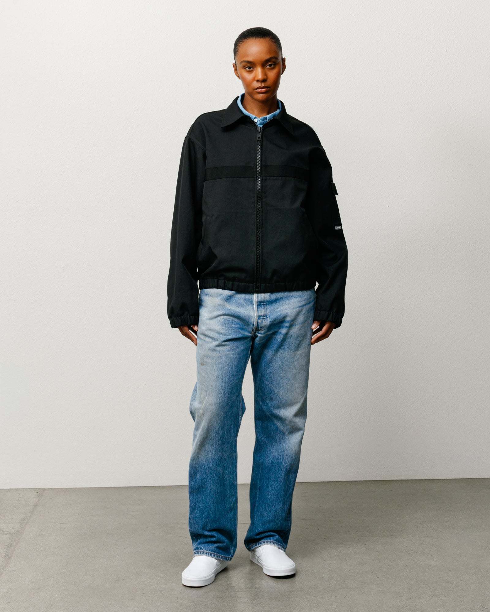 Black Mechanic Jacket With Zip Front And Elastic Hem, Long Sleeves, Shown On Model.