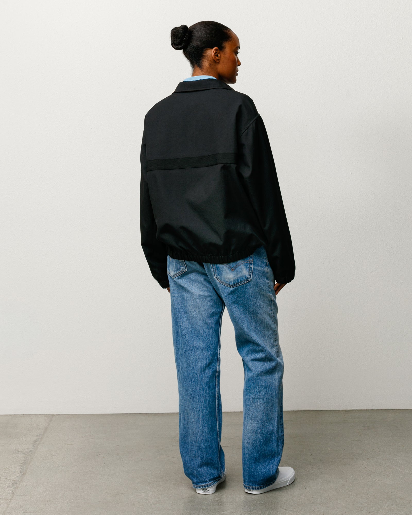 Black mechanic jacket, unisex long sleeve, back view with elastic hem and horizontal webbing.