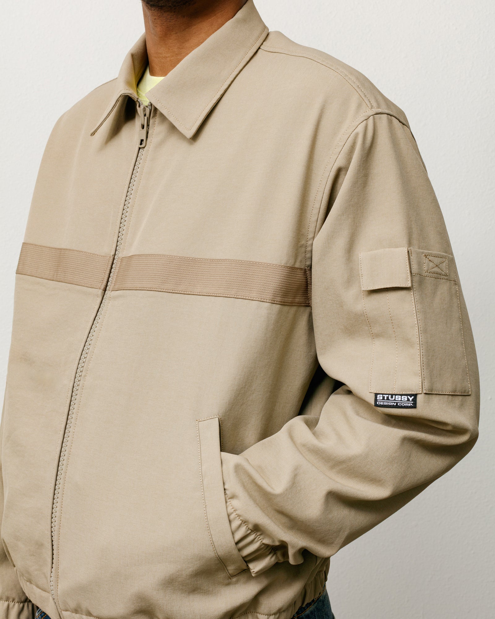 Khaki mechanic jacket with zip front, webbing stripe and sleeve patch pocket