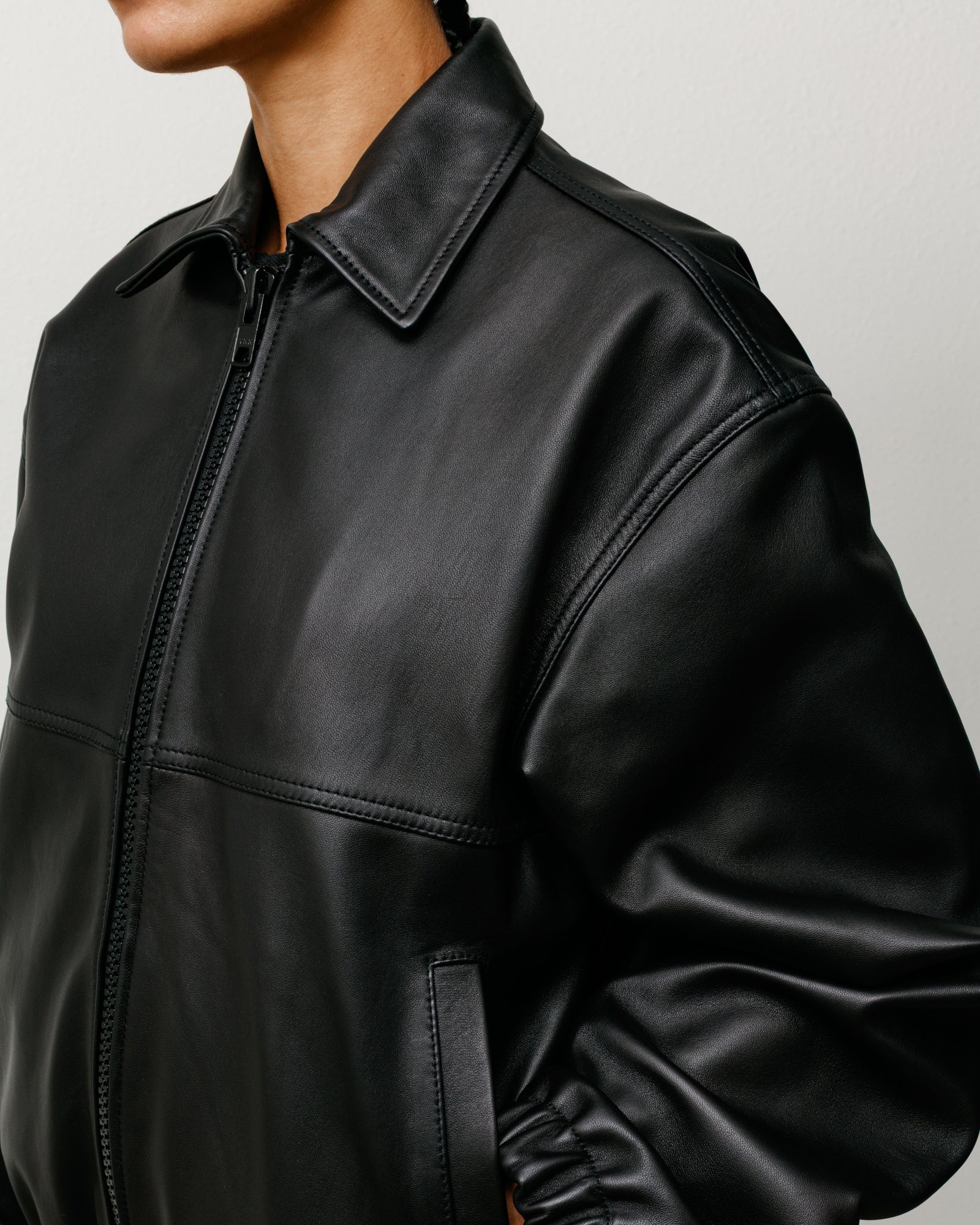 Black leather work jacket with zip front, classic collar and angled welt pockets.