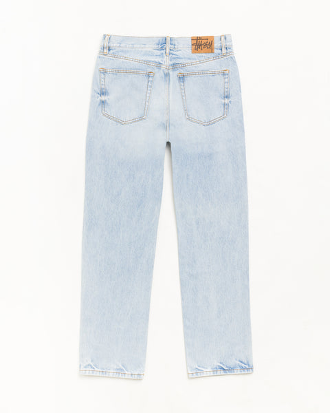 Slim Jean Denim Jean dans le coloris indigo délavé clair, poches dos et patch logo Stüssy.