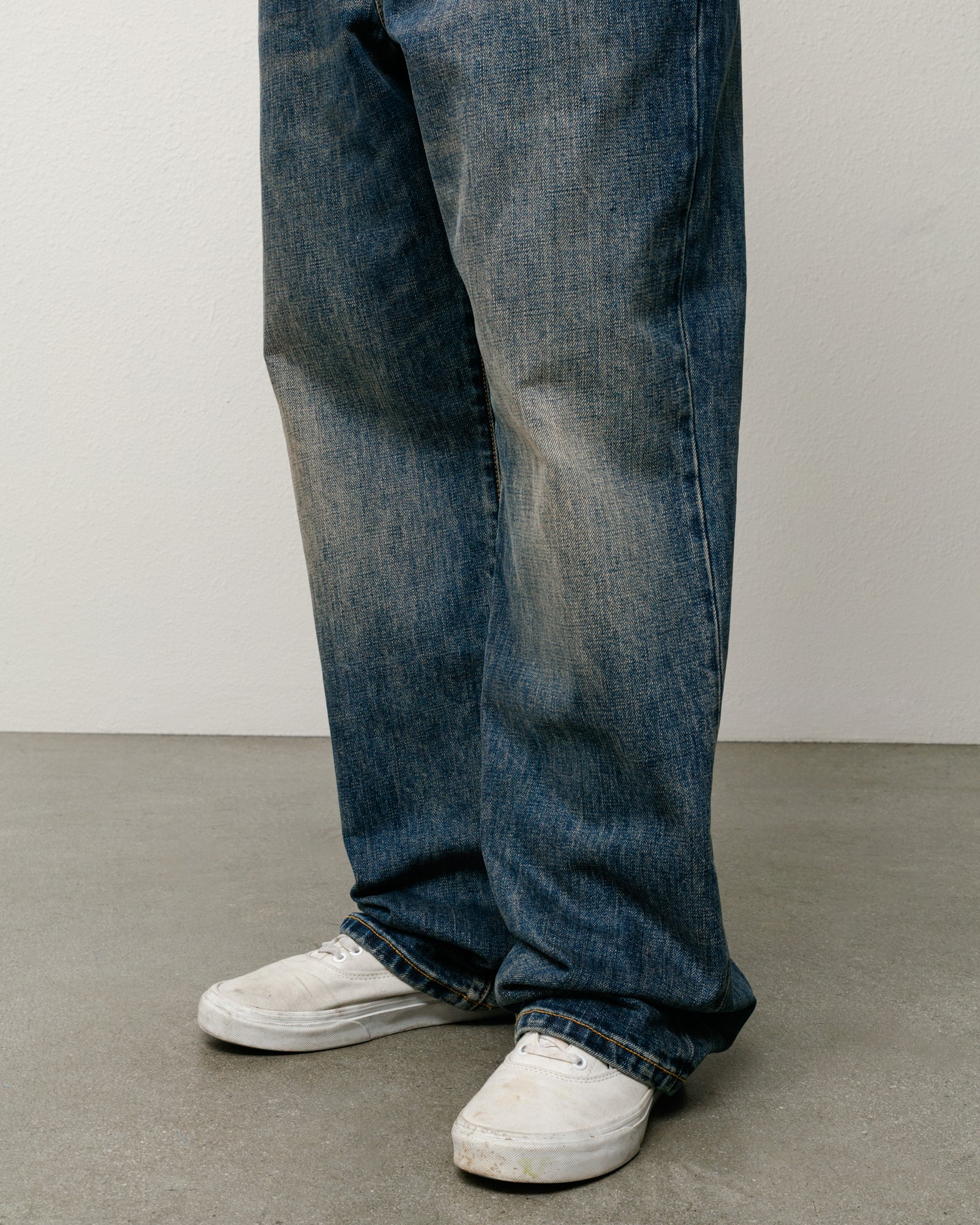 Blue slub denim jeans with a relaxed baggy fit, shown on model legs