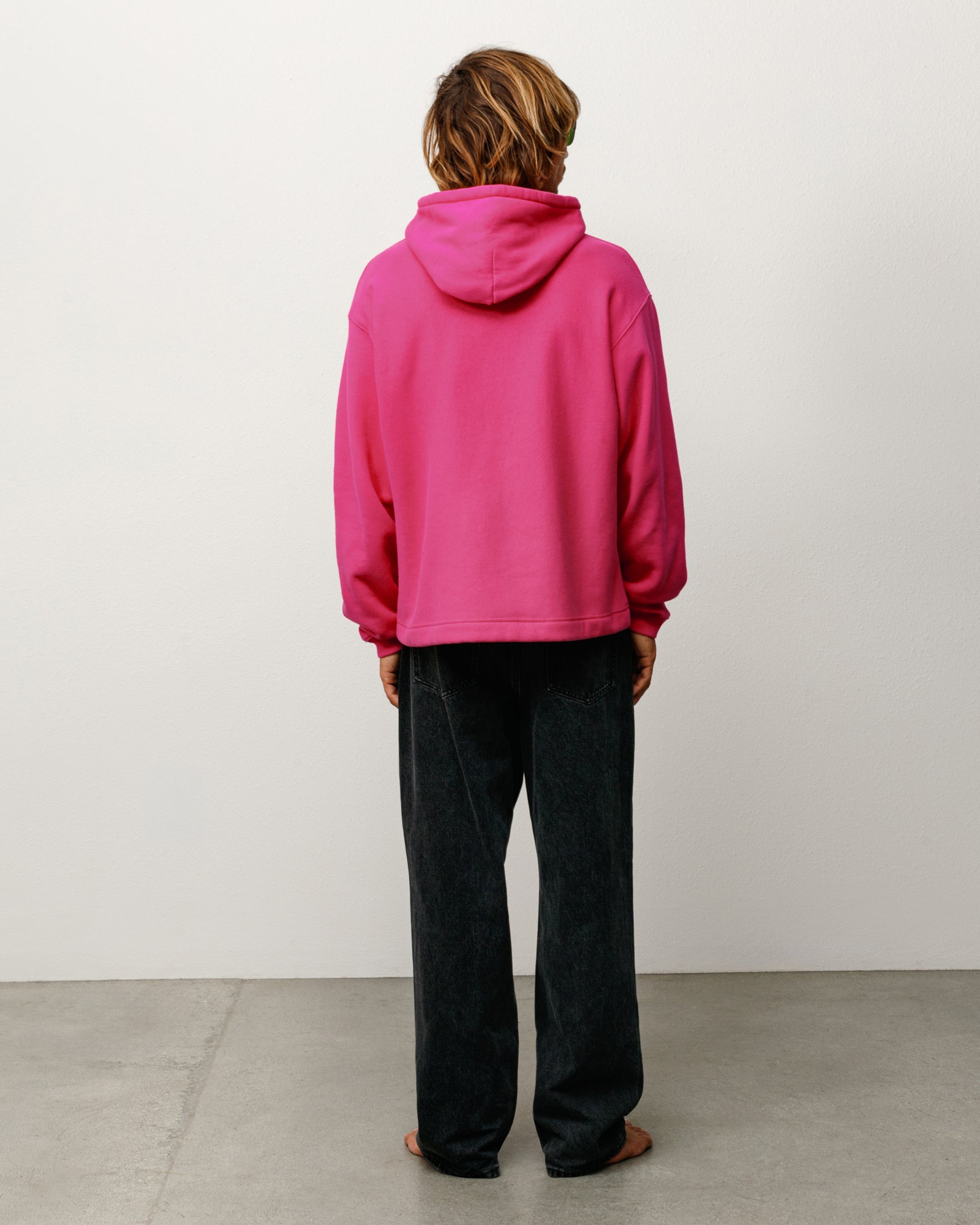 Pink relaxed-fit pullover hoodie, long sleeve, model back view.