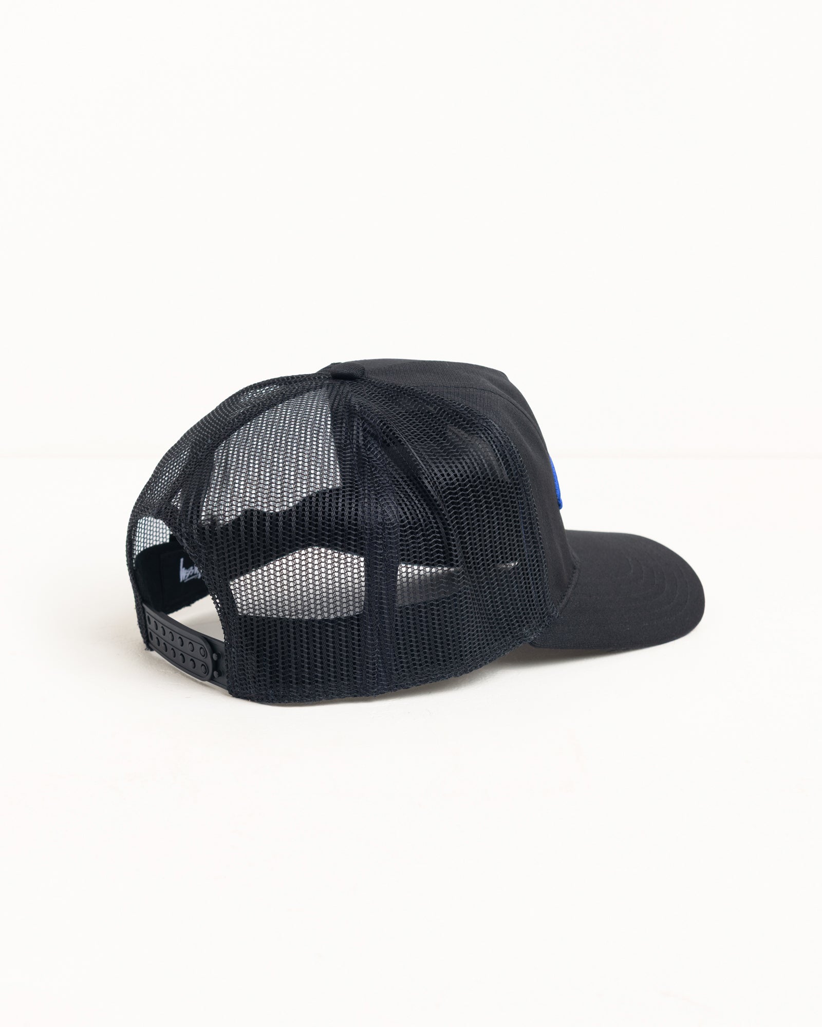 Black mesh-back trucker cap with snapback closure and precurved brim, rear view