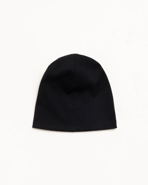 Black jersey skullcap beanie laid flat on a white background