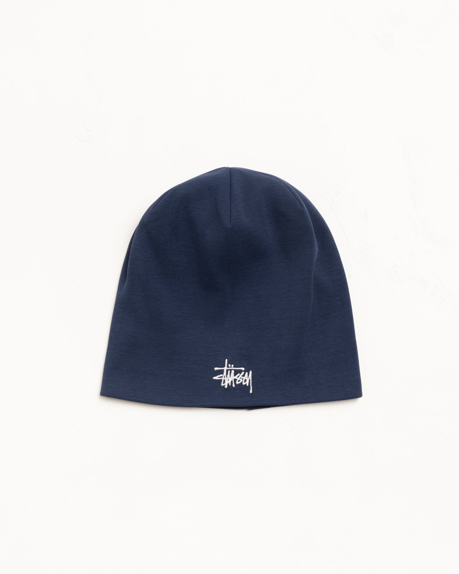 Navy jersey skullcap beanie with white embroidered logo and 6-point crown.