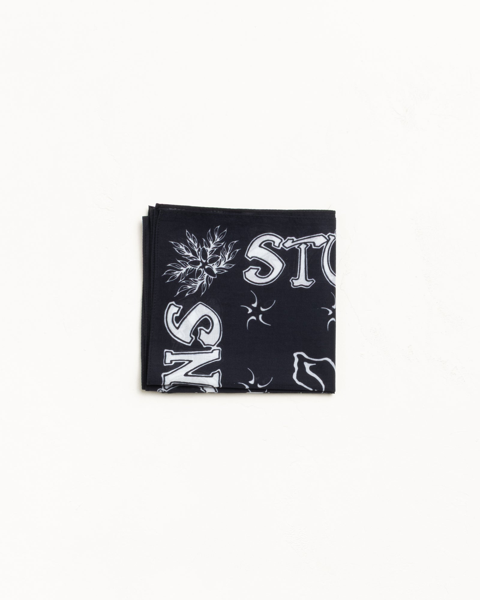 Black cotton bandana with white graphics, folded flat