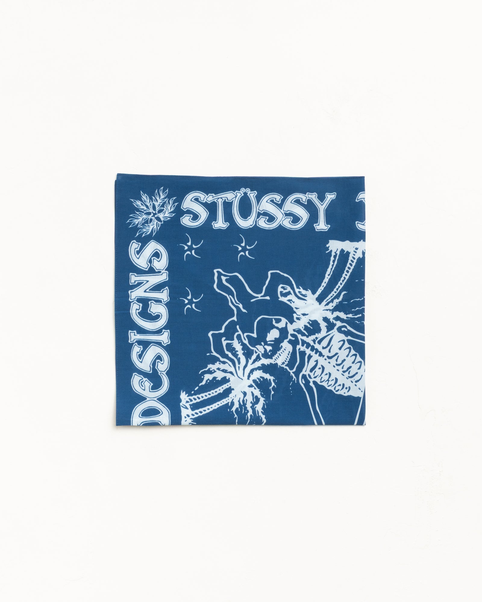 Blue bandana with white graphic artwork and bold lettering, flat-lay view