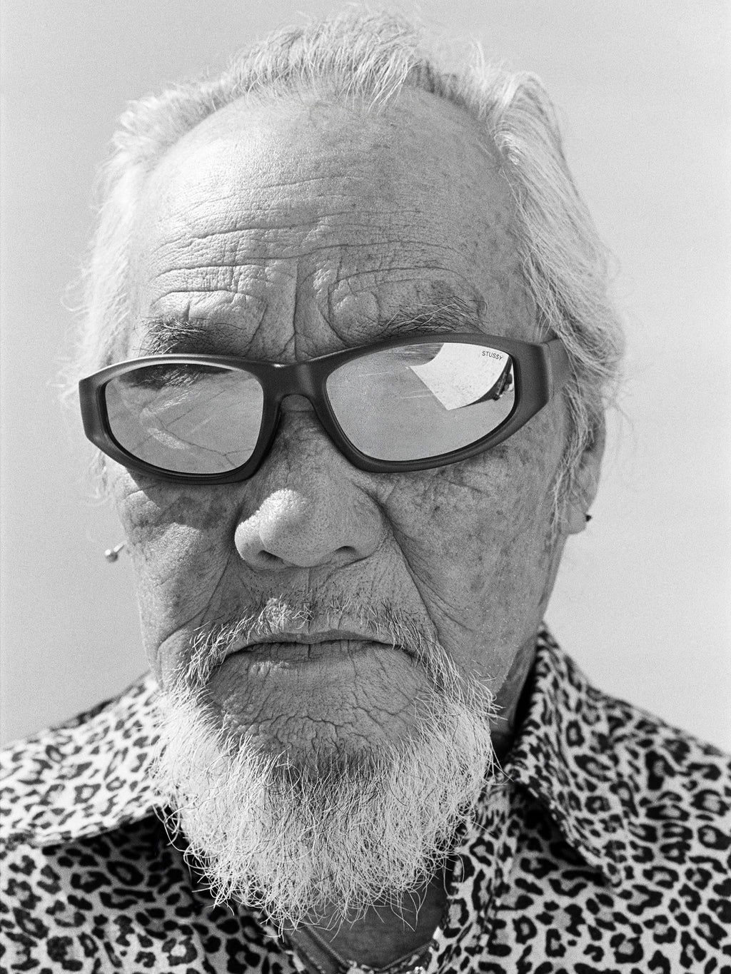 Pops wears the Leslie sunglasses in Matte Black Rubber/Blue Mirror Lens with the Animal Print Flannel Shirt in Leopard.