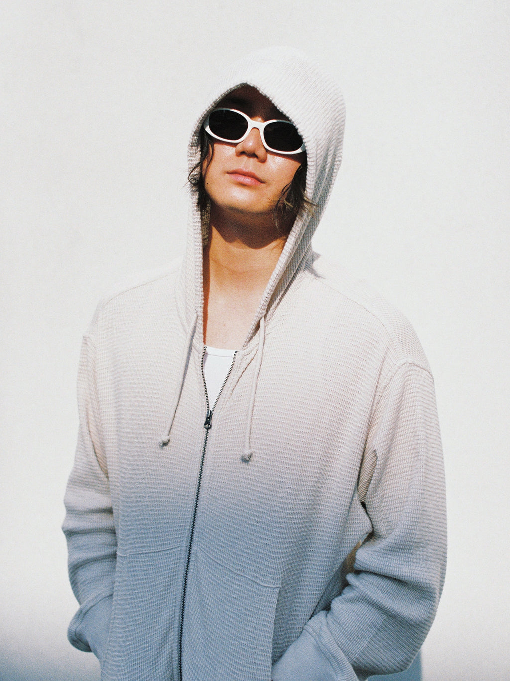 Model wearing the Roman Sunglasses in Bone/Black Lens with the Lightweight Thermal Hoodie in Bone.